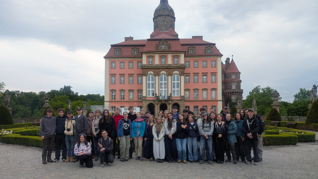 Zdjęcie grupowe studentów i kadry na tle zamku książ